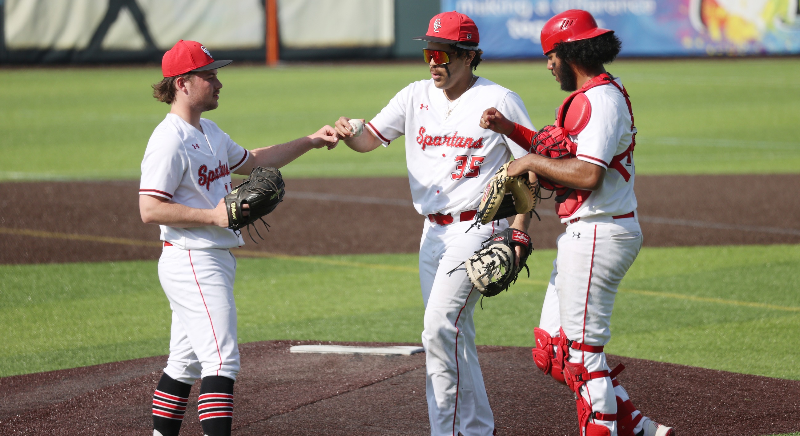 Juan Perez (center) and Antonio Munoz, right, congratulate Jared King after he threw three scoreless innings in the Spartans' 4-0 win over OCC on Wednesday.