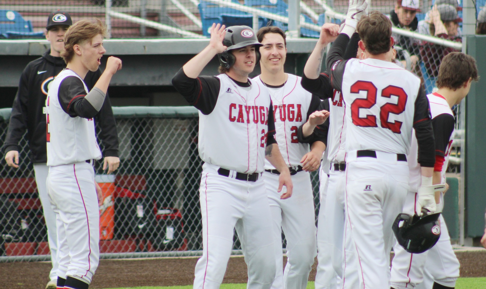 Cayuga's baseball team celebrates during its first game at Falcon Park in Auburn.